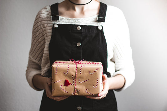 woman holding a gift as if preparing to give to someone